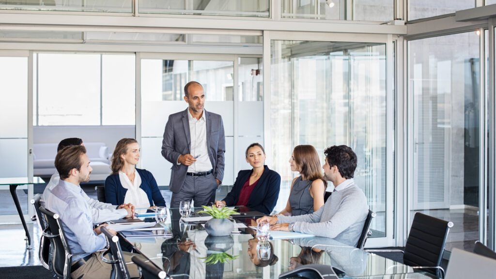 Group of businesspeople sitting in a conference room listening to the human resource manager training people.